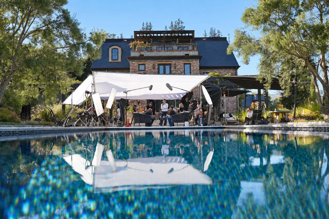 Our production crew lighting and filming an interview beside the pool